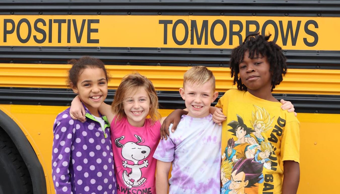 Positive Tomorrows kids by a bus