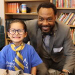 A student shows off his new yellow and blue tie